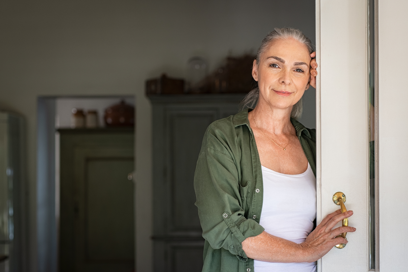 Portrait Of Senior Woman Leaning Against Door At Home And Lookin Empowered Living Strategies